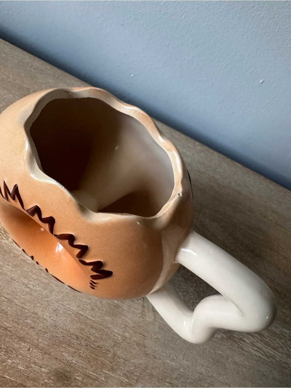 Donut-Shaped Ceramic Mug with Black Frosting and Tan Body